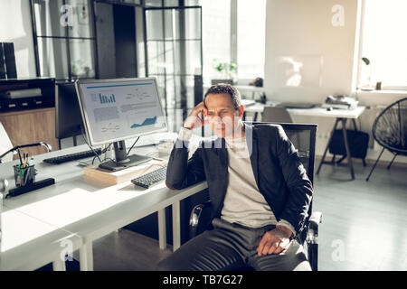 Grauhaarige Geschäftsmann in Kopfschmerzen nach Arbeiten für zu lang. Stockfoto