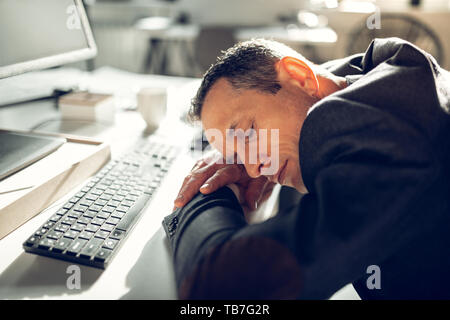 Geschäftsmann Einschlafen am Arbeitstisch Gefühl zu müde Stockfoto