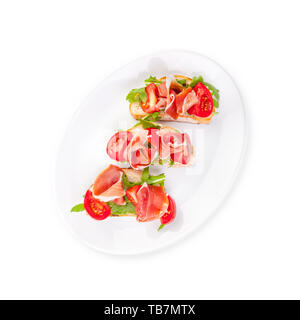 Jamon. Scheiben Brot mit Spanischer Serrano Schinken diente als Tapas. Schinken, spanische Vorspeise. Prosciutto isoliert auf weißem Hintergrund Stockfoto