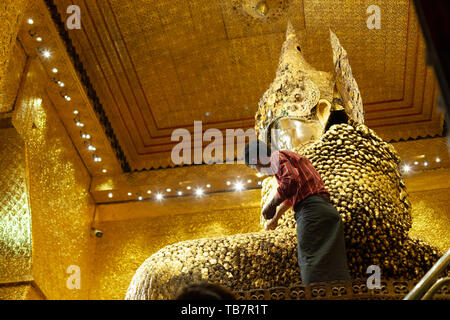 MANDALAY, MYANMAR - Januar 25: Die Gläubigen gelten Quadrate von Blattgold zu den goldenen Buddha Statue an Mahamuni Paya Tempels in Mandalay am 25. Januar Stockfoto