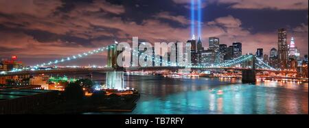 Denken Sie daran, am 11. September. New York City Manhattan Panorama mit Blick auf die Brooklyn Bridge bei Nacht mit Bürogebäude Wolkenkratzer Skyline leuchtet über H Stockfoto