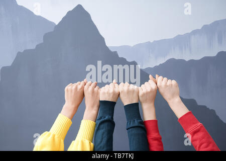 Die Hände der jungen Frauen mit geballten Fäusten auf grauem Hintergrund. Freundschaft Konzept Stockfoto