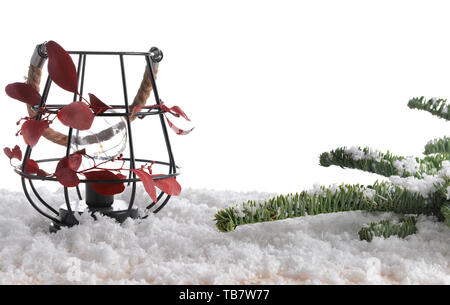 Laterne mit Schnee und Tannenbaum Äste auf holztisch vor weißem Hintergrund Stockfoto