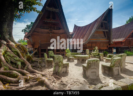 Stein Stühle von Ambarita und traditionellen Batak Dach Häuser, Insel Samosir, Lake Toba Stockfoto