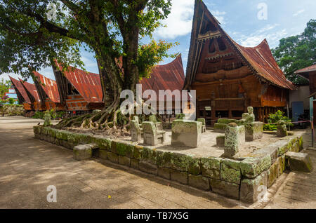 Stein Stühle von Ambarita und traditionellen Batak Dach Häuser, Insel Samosir, Lake Toba Stockfoto