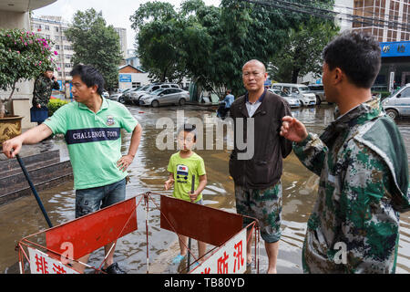 Kunming - 20. Juli 2017 - Bürger aufräumen Gemeinschaft nach starken Regenfällen Stockfoto