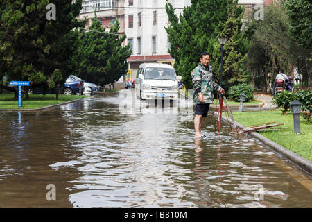 Kunming - 20. Juli 2017 - Bürger aufräumen Gemeinschaft nach starken Regenfällen Stockfoto