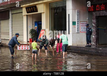 Kunming - 20. Juli 2017 - Bürger aufräumen Gemeinschaft nach starken Regenfällen Stockfoto