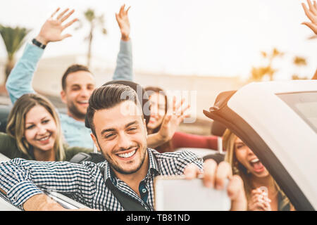 Gerne Freunde unter Foto selfie mit mobilen Smart Phone Kamera im Cabrio - junge Menschen, die Spaß im Cabriolet Auto während Ihres Ausflugs Stockfoto