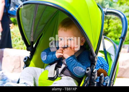 Kleiner Junge sitzt in Pram mit einem lächelnden Gesicht Stockfoto