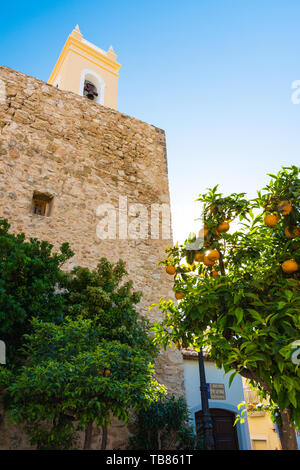 Calpe, Alicante, Spanien. Mai 10, 2019: Glockenturm der alten Kirche hinter dem befestigten Mauer, in der Altstadt Stockfoto