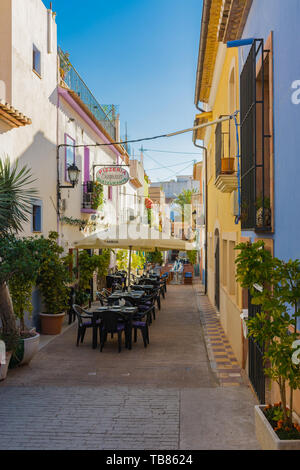 Calpe, Alicante, Spanien. Mai 10, 2019: Straße der Altstadt schmal, mit Terrassen der Bars und bunte Fassaden Stockfoto