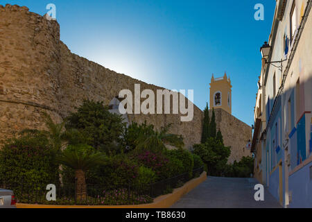 Calpe, Alicante, Spanien. Mai 10, 2019: Befestigte Mauer und Kirche in der Altstadt. Es gibt zwei alte Kanonen neben dem Eingang Portal Stockfoto