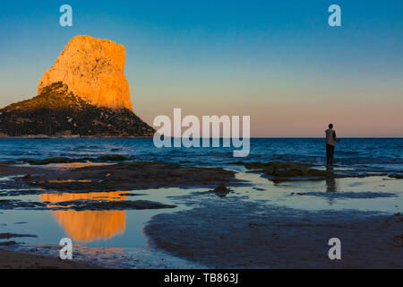 Calpe, Alicante, Spanien. Mai 10, 2019: Sonnenuntergang in der Arenal Strand. Fischer und Felsen von Ifach mit Sonnenlicht Stockfoto