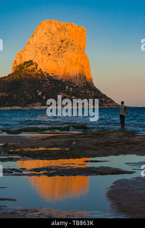 Calpe, Alicante, Spanien. Mai 10, 2019: Sonnenuntergang in der Arenal Strand. Fischer und Felsen von Ifach mit Sonnenlicht Stockfoto