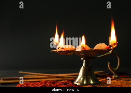 Diya Lampe mit Gewürzen für die Feier des Divaly auf dunklem Hintergrund Stockfoto