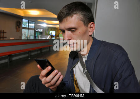 Hübscher junger Mann. Der Einsatz von modernen Smartphones im modernen Leben Stockfoto