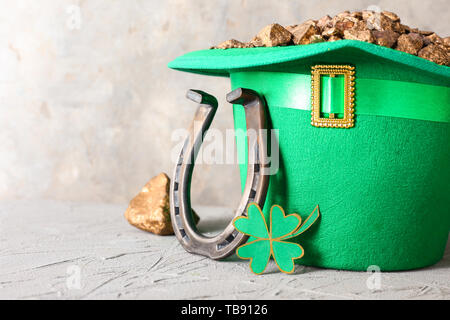 Zusammensetzung mit der Kobold Schatz, Hufeisen und Klee für St. Patrick's Day auf grau Tabelle Stockfoto