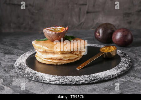Leckere Pfannkuchen mit Passionsfrucht auf schiefer Platte Stockfoto