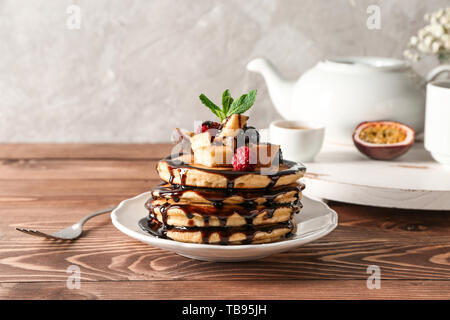 Leckere Pfannkuchen mit Leidenschaft Obst und Beeren auf hölzernen Tisch Stockfoto