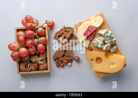 Auswahl an leckeren Käse mit Snacks auf hellen Hintergrund Stockfoto