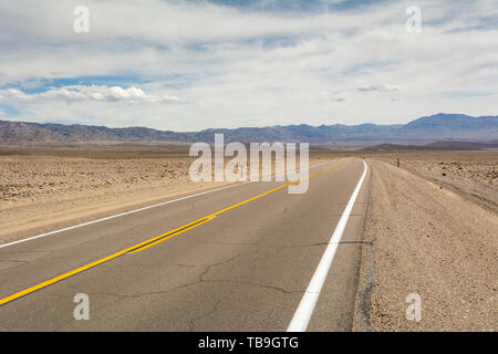 Death Valley Road quer durch die Wüste, die Berge in der Ferne. Kalifornien, USA Stockfoto