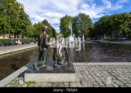 Bronzestatue von zwei Kindern am See in Spikersuppa Park in Oslo Stadtzentrum suchen, Norwegen Stockfoto