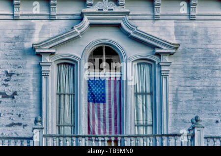 Eine amerikanische Flagge hängt im Fenster eines historischen Südlichen antebellum Home in die Seventh Street North in der Innenstadt von Columbus, Mississippi. Stockfoto
