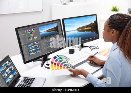 Junge weibliche Editor Videobearbeitung am Computer im Büro Stockfoto