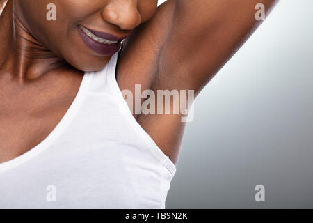 Nahaufnahme einer Frau, sauber Achselhöhlen auf grauem Hintergrund Stockfoto