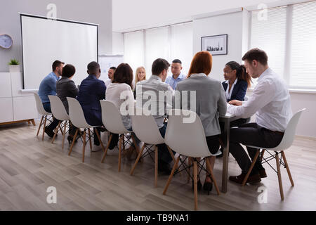 Gruppe von Multiethnischen Diverse beschäftigten Geschäft Leute sitzen zusammen am Tisch im Büro Stockfoto