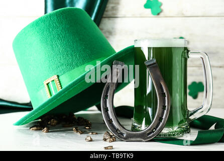 Leprechaun hut mit Krug Bier und Hufeisen auf weißer Tisch. St. Patrick's Day Celebration Stockfoto