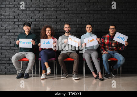 Junge Menschen, die eine neue Blätter mit Worten JOB UND KARRIERE im Innenbereich Stockfoto