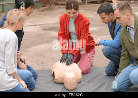 Kursleiter Vorführen der Herz-Lungen-Wiederbelebung auf Mannequin bei Erste Hilfe training Stockfoto