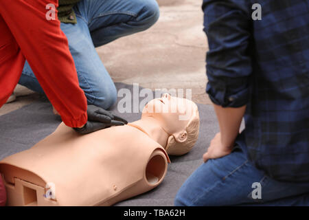 Kursleiter Vorführen der Herz-Lungen-Wiederbelebung auf Mannequin bei Erste Hilfe training Stockfoto
