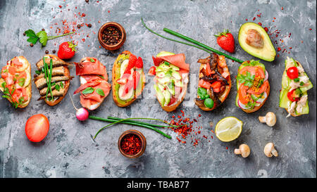 Sortierte Bruschetta mit verschiedenen Toppings. Appetitlich bruschetta. Vielzahl von kleinen Sandwiches. Mix bruschetta Stockfoto