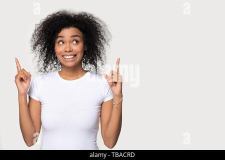 Afrikanische Frau beiseite stehend Grau leer Pointing Finger nach oben Stockfoto