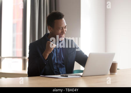 Aufgeregt schwarze Unternehmer fühlen sich euphorisch Lesen gute Nachrichten online Stockfoto