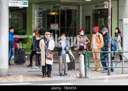 Tokyo, Japan - 30. März 2019: Shinjuku Straße Gehweg mit Menschen auf der Straße Bürgersteig von Station zu errichten, die während des Tages Stockfoto