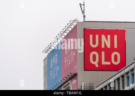 Tokyo, Japan - 30. März 2019: Shinjuku modernes Gebäude an bewölkten Tag mit roten Schild in englischer Sprache für Uniqlo shop shop von Station Stockfoto