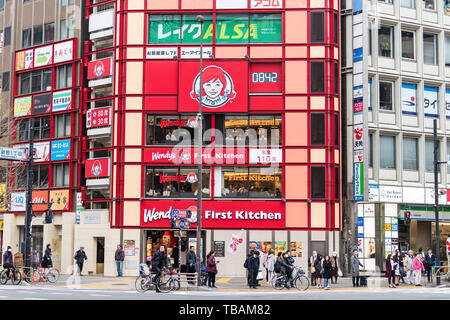 Tokyo, Japan - 30. März 2019: Shinjuku Straße Gehweg mit vielen Menschen in der Nähe der Eingang zu Wendy's Fast Food Restaurant mit Zeichen für erste Küche Stockfoto