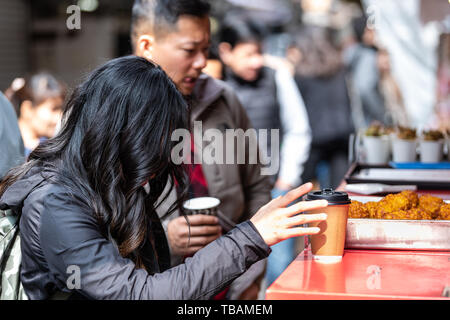 Tokyo, Japan - 31. März 2019: Tsukiji Markt Ginza mit Menschen stehen mit Kaffee trinken im Markt durch Fried food Vendor Stockfoto