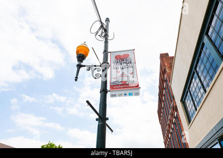 Asheville, USA - 19. April 2018: Innenstadt Altstadt Straße in hipster North Carolina NC-berühmte Stadt mit Banner auf Lamp Post für Liebe und lokalen Stockfoto