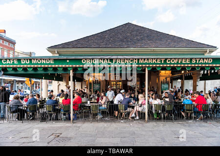 New Orleans, USA - 22. April 2018: die Leute an den Tischen sitzen im legendären Cafe Du Monde Restaurant anmelden Essen beignet Puderzucker Donuts und Zichorien c Stockfoto