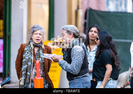 New Orleans, USA - 23. April 2018: Frau und Mann älteres Ehepaar miteinander reden Essen fast food in Louisiana Bourbon Street Stockfoto