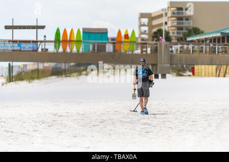 Fort Walton Beach, USA - 24. April 2018: Zurück der Mann Arbeiter gehen auf Sand Strand in Okaloosa Island auf der Suche nach Metall mit Detektor gerät Werkzeug in Stockfoto