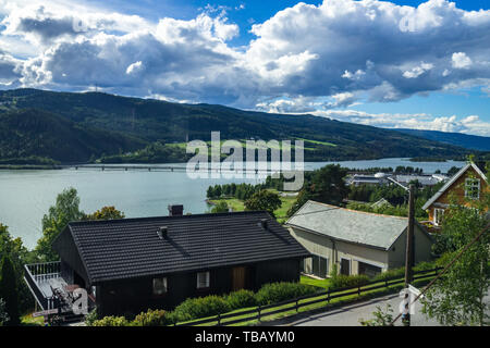 Häuser am Ufer des Sees in der Nähe von Lillehammer mit Mjosa Vingnesbrua Straße Brücke verbindet die beiden Seite des Sees, Oppland, Norwegen Stockfoto