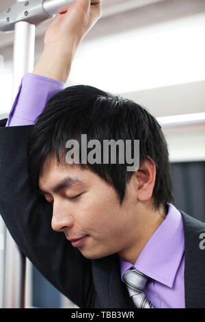 Ein Mann fährt mit der U-Bahn während der Fahrt zur und von der Arbeit Stockfoto