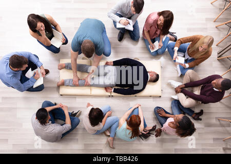 Gruppe von Menschen im Kreis Lernen Massagetechnik Sitzen Stockfoto