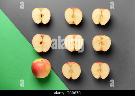 Einen ganzen Apfel unter Schnitt, auf grauem Hintergrund. Einzigartigkeit Konzept Stockfoto